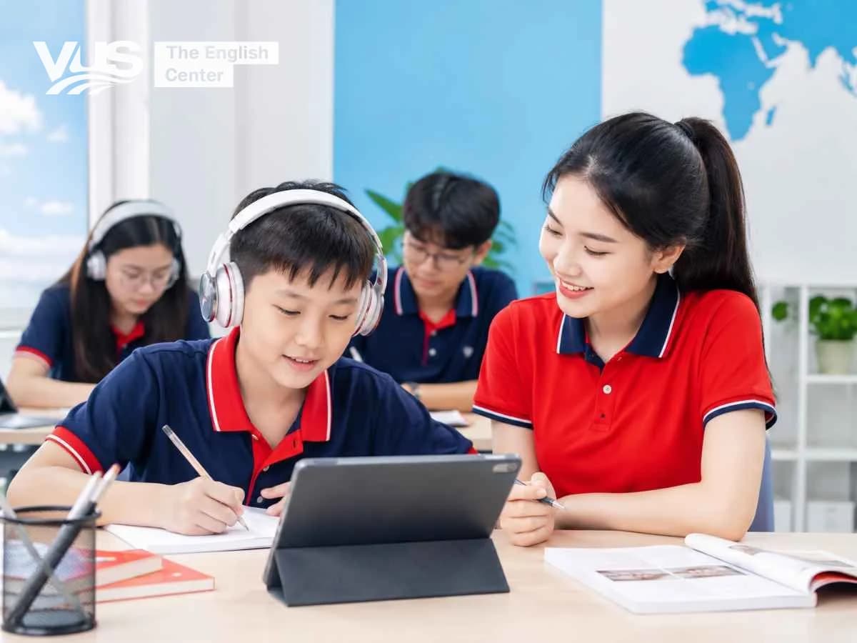 Học sinh Việt Nam học kỹ năng nghe tiếng Anh cùng giáo viên trong lớp hiện đại, minh họa cho việc nghe tốt trong lớp nhưng khó nghe ngoài đời.